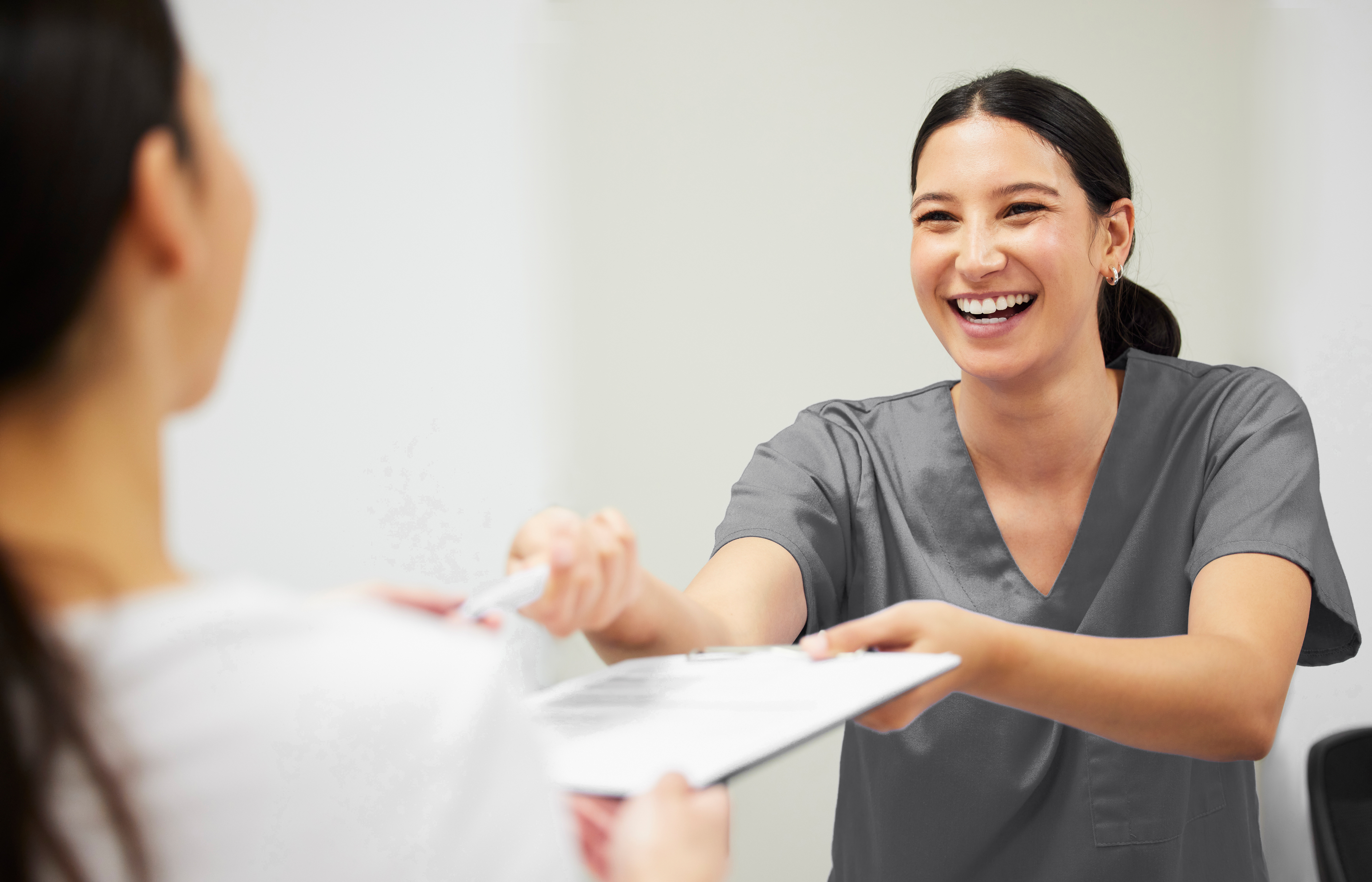 Documents, happy and a nurse helping a patient in the hospital during an appointment or checkup. Insurance form, smile and a medical assistant at a health clinic to help with check in or sign up